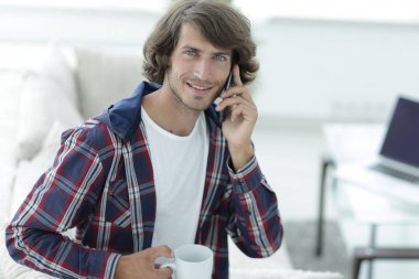 güzel bir fincan adamla bir dizüstü bilgisayar önünde oturur.