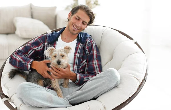 yakışıklı olan büyük bir koltukta oturan bir köpekle.