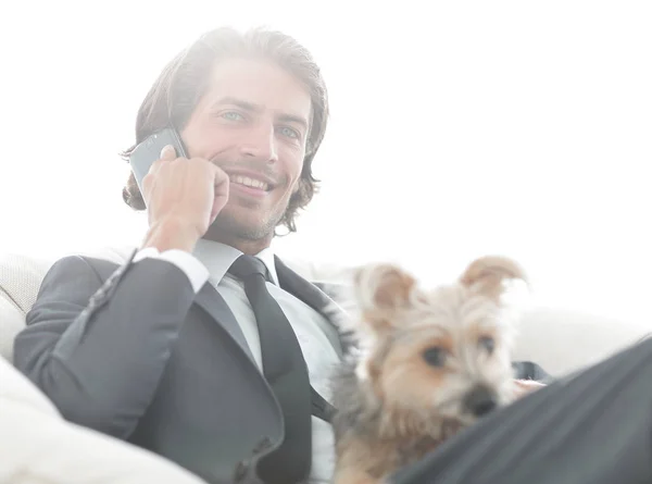 Primer plano de un hombre de negocios hablando por teléfono y sosteniendo a su mascota . — Foto de Stock