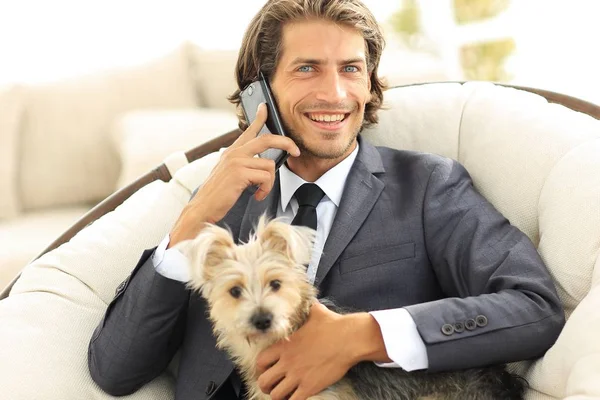 business man talking on the phone and holding his pet