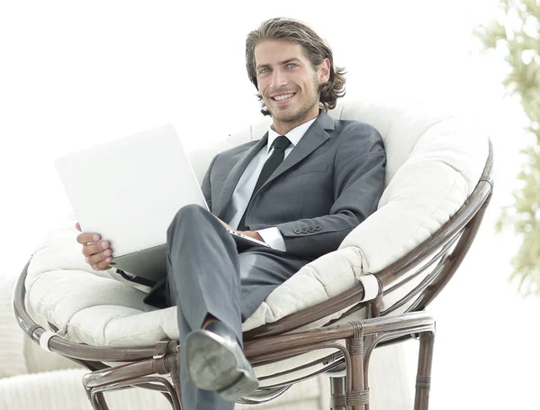 Confident businessman working with laptop sitting in comfortable armchair — Stock Photo, Image