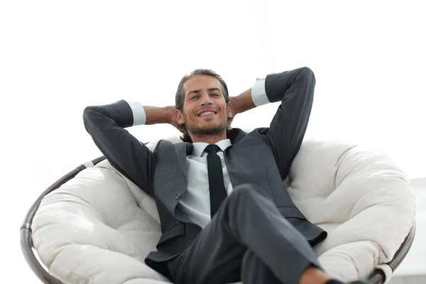 Succesvolle zakenman zitten in een grote comfortabele stoel — Stockfoto