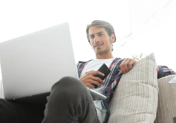 Framgångsrik kille sitter på soffan i vardagsrummet — Stockfoto