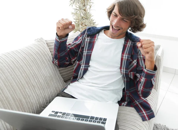 Heureux jeune homme regardant l'écran d'ordinateur portable — Photo