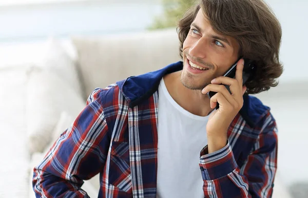 Hermoso chico con una taza se sienta delante de un ordenador portátil . — Foto de Stock