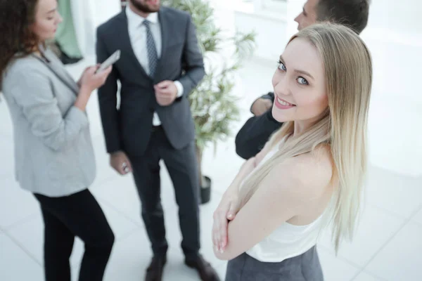 Framgångsrik ung kvinna - anställd i ett företag mot bakgrund av kollegor — Stockfoto