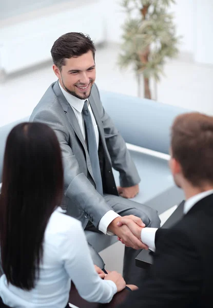 Socios comerciales de apretón de manos en el vestíbulo de la oficina . — Foto de Stock