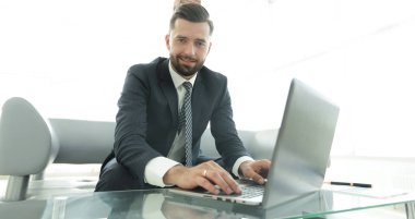 Modern ofis dizüstü bilgisayarda çalışan başarılı erkeğin