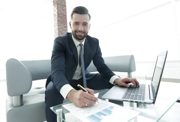 Homme d'affaires travaillant avec des graphiques d'entreprise sur un ordinateur portable — Photo