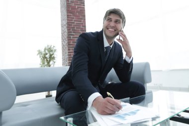 İş yerinde akıllı telefonu olan bir iş adamı.