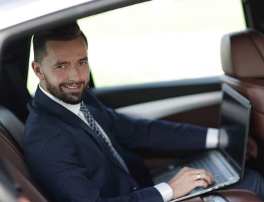 Otomatik olarak oturan dizüstü bilgisayar ile kendine güvenen iş adamı.