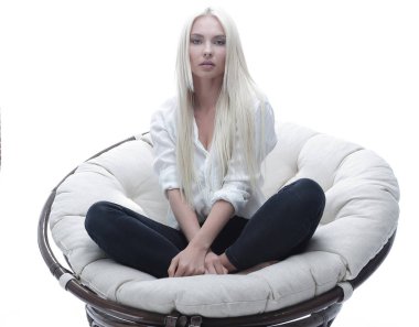 büyük bir rahat tekli koltukta oturan güzel genç kadın.