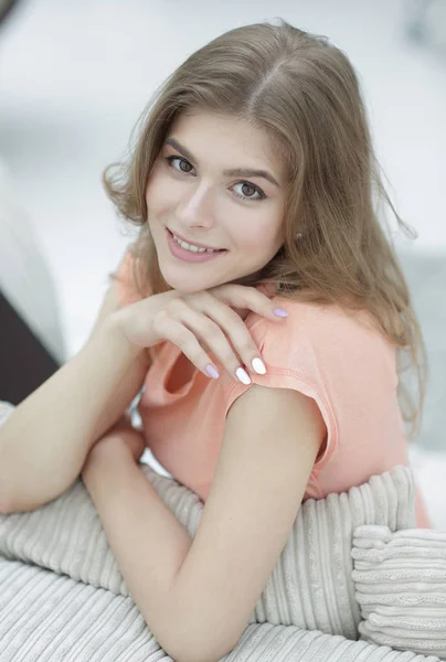 Porträt einer jungen lächelnden Frau im Hintergrund des Wohnzimmers. — Stockfoto