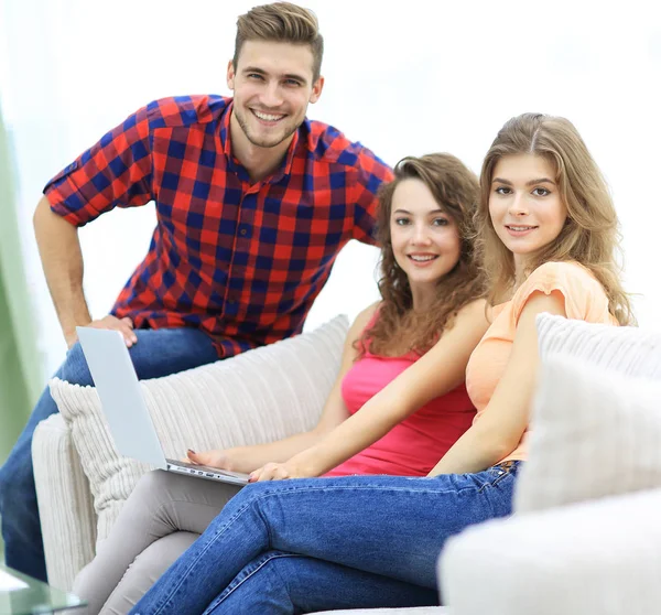 Grupo de jovens sentados no sofá na sala de estar . — Fotografia de Stock