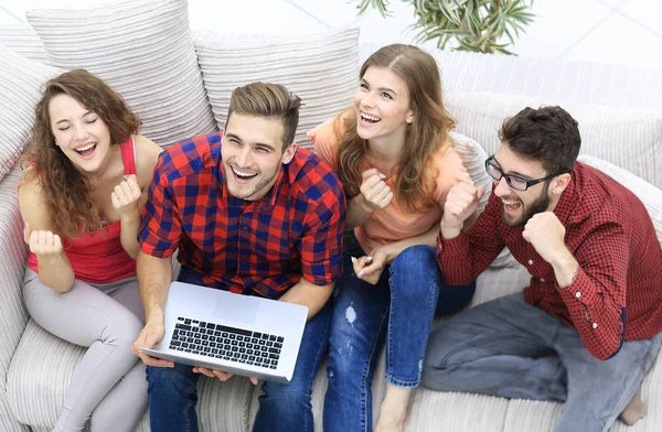 Gruppe von Freunden schaut sich ein Video auf einem Laptop an und lacht — Stockfoto