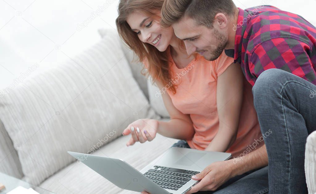 young couple watching videos on laptop