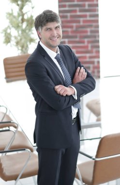 Bir boş toplantı odasında duran iş adamı