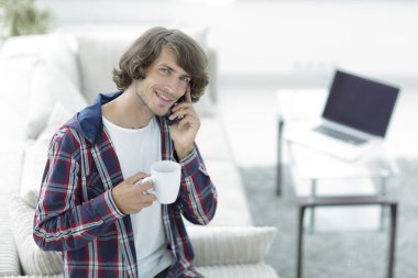 güzel bir fincan adamla bir dizüstü bilgisayar önünde oturur.