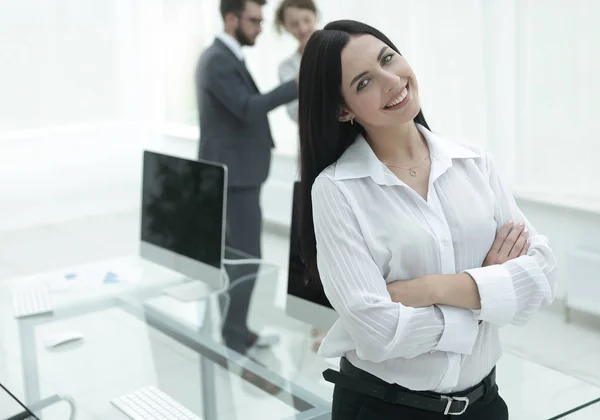 Giovane donna d'affari di successo sullo sfondo di un posto di lavoro — Foto Stock