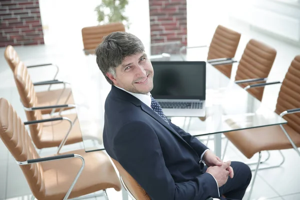 Smiling manager sitting at work desk in meeting room. — Stock Photo, Image