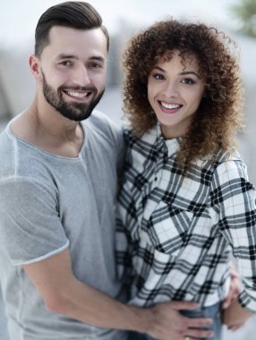 mutlu genç çift birbirlerine sarılıyor.