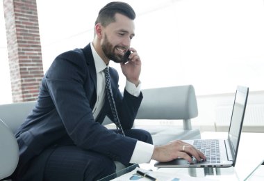 Smartphone üzerinde konuşmak ve metin dizüstü bilgisayarda yazarak işadamı