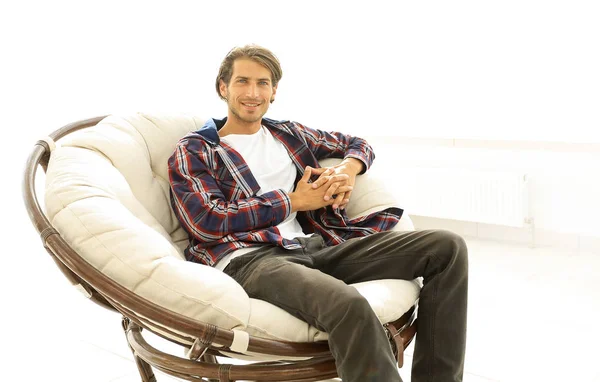 Hombre moderno sentado en una silla cómoda grande . — Foto de Stock