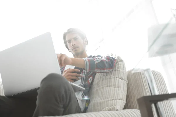 Photo jeune homme avec smartphone assis sur une chaise. sur un fond flou — Photo