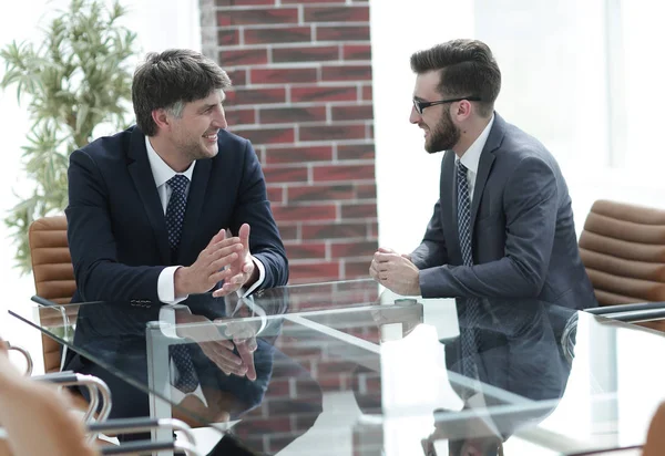 iki işadamı görevleri Office masada oturan tartışıyor.