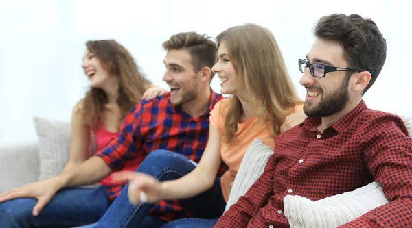 Grupo de jóvenes sonrientes sentados en el sofá —  Fotos de Stock