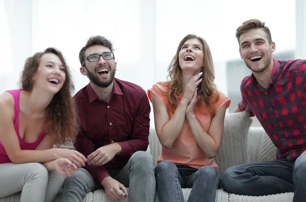 Gruppe fröhlicher junger Leute sitzt auf der Couch. — Stockfoto