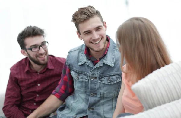 Grupo de jovens conversando sentado no sofá — Fotografia de Stock