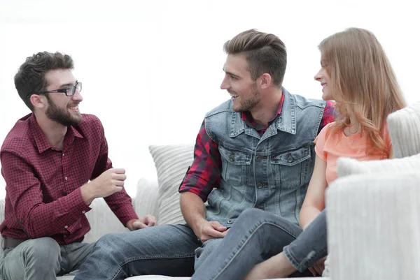 Група молодих людей розмовляє сидячи на дивані — стокове фото