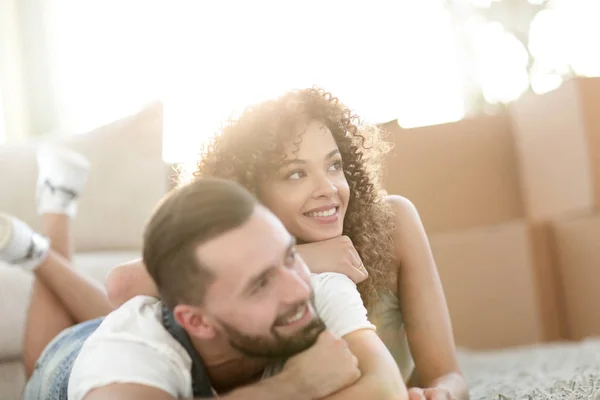 Pareja feliz acostada en la alfombra sobre el fondo borroso —  Fotos de Stock