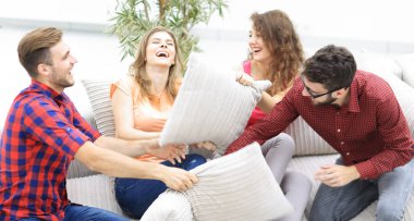 neşeli arkadaşları kanepede oturan yastık ile oynarken