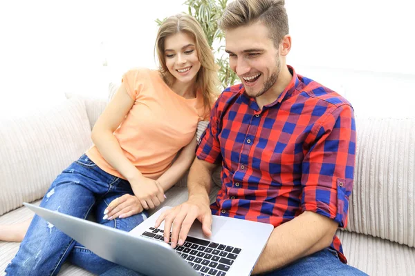 Feliz pareja moderna navegando por la red y trabajando en el ordenador portátil en casa — Foto de Stock