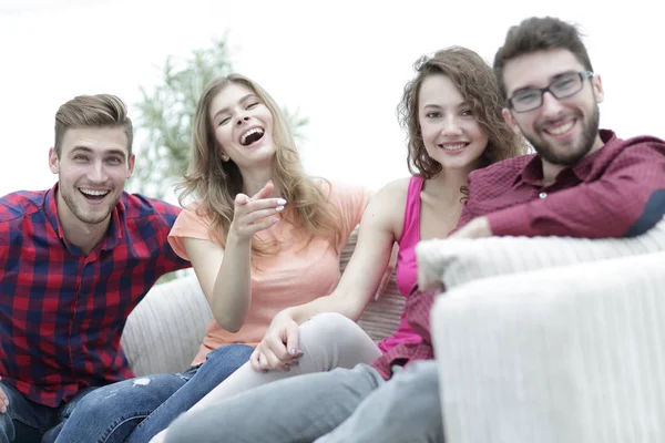 Skupina happy mladých lidí sedí na gauči — Stock fotografie