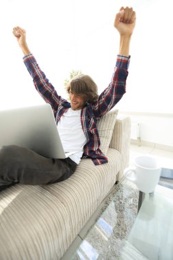 çok mutlu genç adam evde laptop ile çalışma.