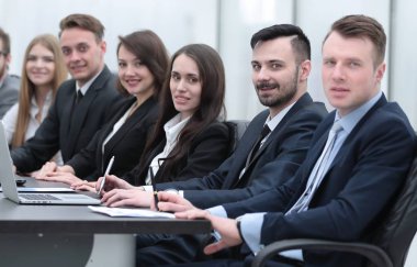 İş ekibi konferans odasındaki masada oturuyor.