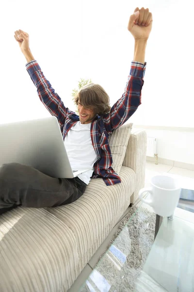 çok mutlu genç adam evde laptop ile çalışma.