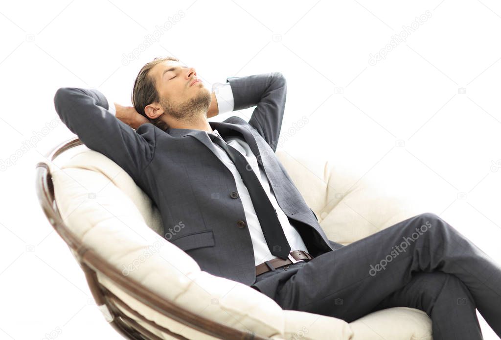 young businessman meditating in big comfortable armchair