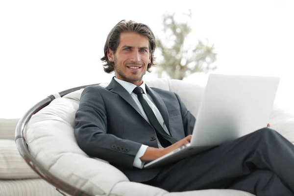Biznesmen z laptopa siedząc w stylowych, komfortowych chai — Zdjęcie stockowe