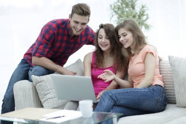 kanepede oturan bir dizüstü ekran bakarak öğrenci grubu