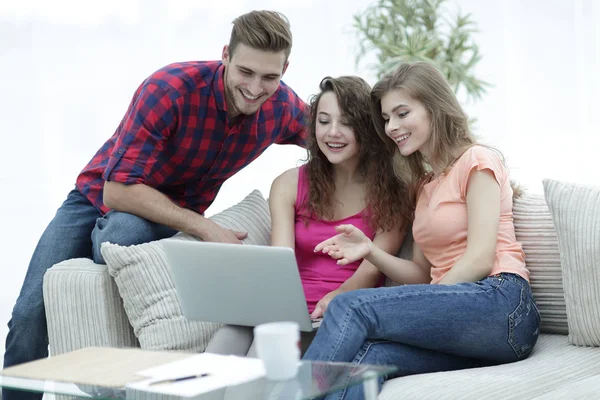 kanepede oturan bir dizüstü ekran bakarak öğrenci grubu