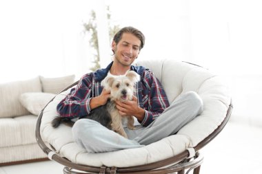 yakışıklı olan büyük bir koltukta oturan bir köpekle.