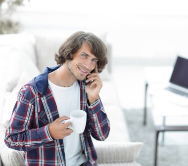 güzel bir fincan adamla bir dizüstü bilgisayar önünde oturur.