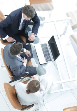 Bir toplantı odası masa etrafında toplantı üç iş adamları