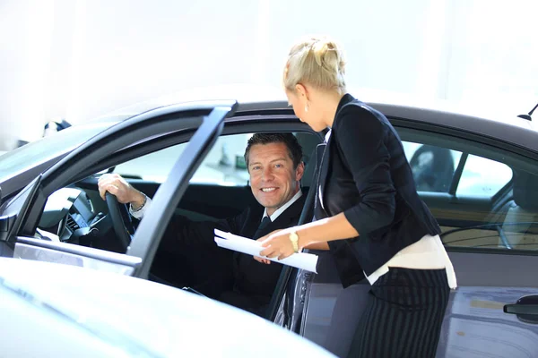 Successful business man sitting behind the wheel of a new car — Stock Photo, Image