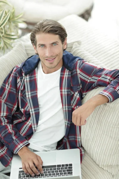 dizüstü bilgisayarda çalışan ve kameraya bakarak başarılı adam. Yukarıdan görüntülemek