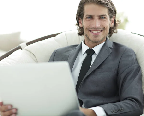 Κοντινό πλάνο του χαμογελώντας επιχειρηματίας που εργάζεται με το laptop στο σαλόνι. — Φωτογραφία Αρχείου